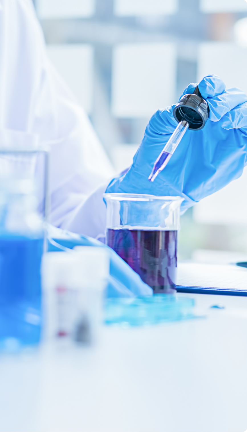 lab-eye-dropper-and-beaker Lab technician removing purple liquid from beaker using an eye dropper.