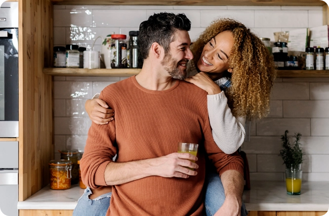 Couple talking together in the home kitchen.