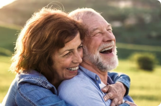 older man and woman laughing together.