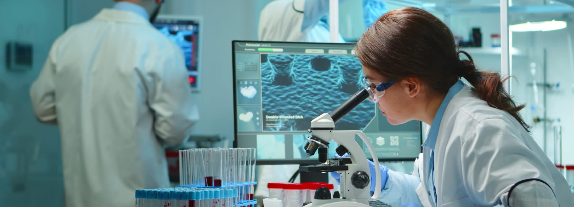 Laboratory scientists reviewing samples and microscopy work, illustrating supplement research and development.