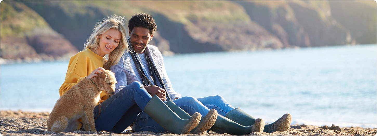 kaneka-nutrients-male-preconception-inline-image male and female couple sitting on a beach with their dog
