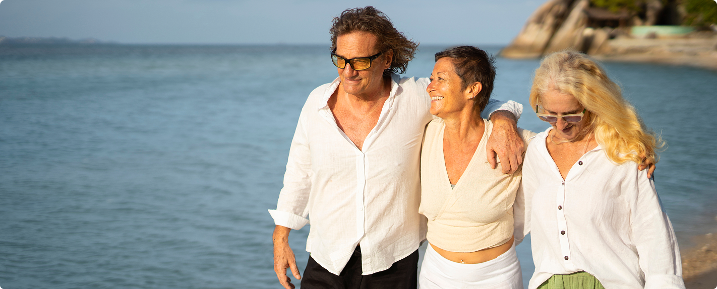 Three active older adults walking on a beach, illustrating cellular health as the foundation for aging well.